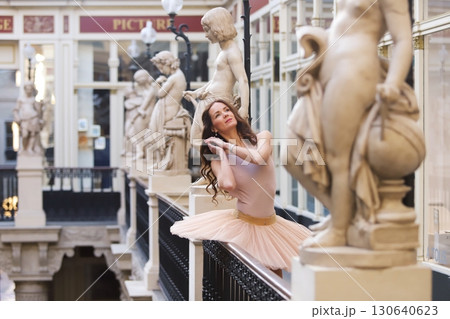 Ballet dancer posing near statues in historic gallery 130640623