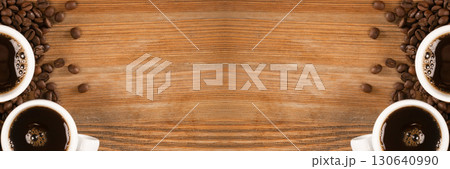 Hot coffee cup and coffee beans on brown background top view 130640990