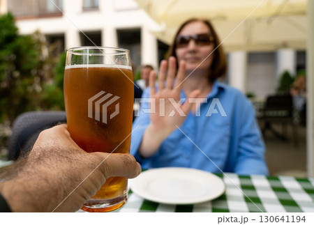 Reject a glass of beer, woman refusing alcohol, stop drinking, sobriety concept, saying no to beer glass 130641194