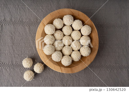 Coconut candies pile, coco ball. White truffle ball, indian ladoo or laddu with sweet cream and coco Coconut candies pile, coco ball. White truffle ball, indian ladoo or laddu with sweet cream and coco 130642520
