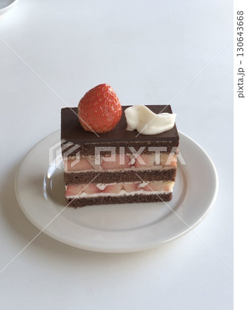 A delectable slice of cake with rich layers of cream and frosting, topped with fresh fruit or sprinkles. Perfect for dessert photography, showcasing indulgence and sweetness in food-related projects. 130643668