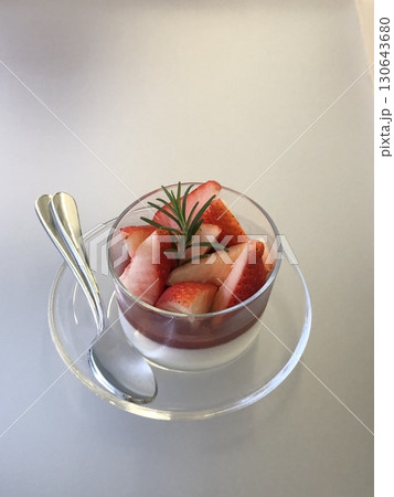 Healthy breakfast of strawberry parfait made with fresh fruit, and yogurt over a rustic white table. Selective focus with blurred background and foreground. Healthy breakfast of strawberry parfait made with fresh fruit, and yogurt over a rustic white table. Selective focus with blurred background and foreground. 130643680