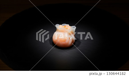 Single Shrimp Dumpling on Black Plate with Spotlight 130644182