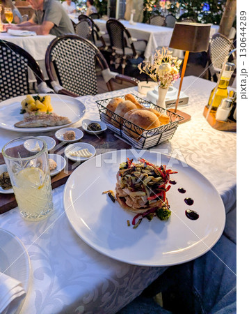 A gourmet vegetable dish served on a white plate with sauce details. Culinary art, lifestyle dining, and cultural experience through restaurant presentation and gourmet food. 130644289