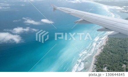 Passengers enjoy breathtaking ocean views from the airplane wing while flying above the coastline 130644845
