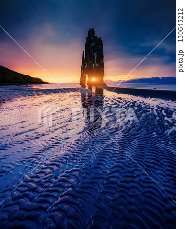Textured dark sand after the tide. Location famous Hvitserkur rock, Vatnsnes peninsula, Iceland, Europe. 130645212