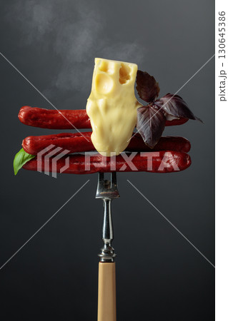 Grilled thin sausages with cheese and basil. Grilled thin sausages with cheese and basil. 130645386