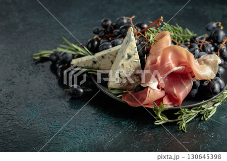Prosciutto with blue cheese, grapes, and rosemary. 130645398