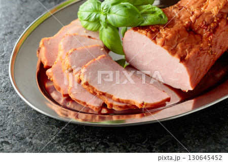Delicious smoked ham with basil on a metal tray. 130645452