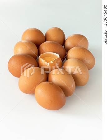 view of Egg yolk in Broken raw chicken eggshell in the among of Fresh chicken egg on white background. 130645490