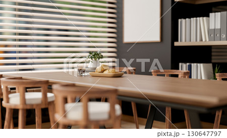 The bread on plate and coffee cup on wooden table with armchairs next to window in office break room 130647797