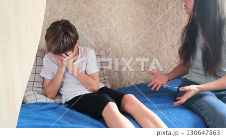 Angry mother is scolding at her son. Family conflict. Adolescence, a teenage boy, and a parent. 130647863
