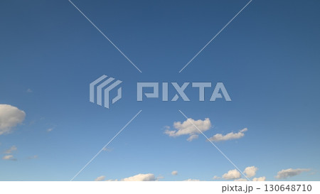 The Sky is a Clear, Bright Blue, Decorated with Fluffy, White Clouds Floating Gracefully 130648710