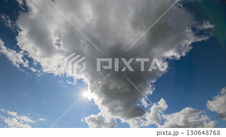 A Cloudy Sky Displaying Beautiful Sunlight Gently Peeking Through the Fluffy Clouds Up Above 130648768