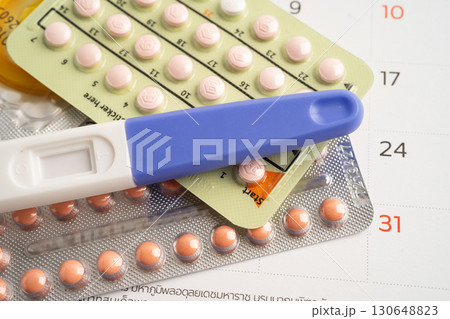 Pregnancy test and birth control pills on calendar, contraception health and medicine. 130648823