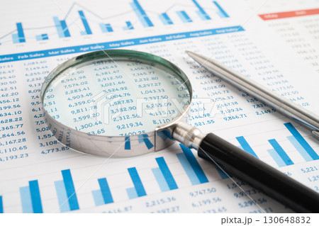 Magnifying glass on spreadsheet and graph paper. Financial data economy, Business. Magnifying glass on spreadsheet and graph paper. Financial data economy, Business. 130648832
