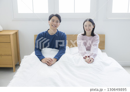 ベッドでリラックスする夫婦 130649895