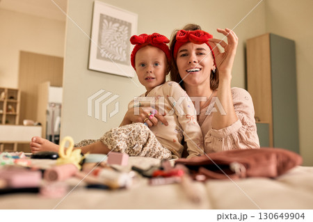 Mother and daughter enjoying playful bonding time with beauty products at home Mother and daughter enjoying playful bonding time with beauty products at home 130649904