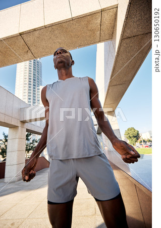 Athlete standing confidently outdoors under sunny urban architectural elements Athlete standing confidently outdoors under sunny urban architectural elements 130650192