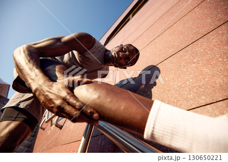 Dedicated athlete stretching outdoors during an intense fitness routine for flexibility 130650221