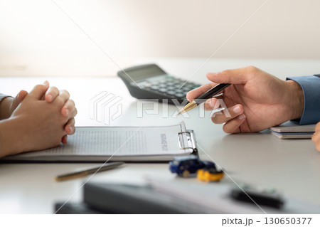 Financial Consultation. Professional discussing car insurance options with client. 130650377