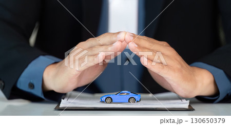 Insurance Consultation. Professional shielding model car during client meeting. 130650379