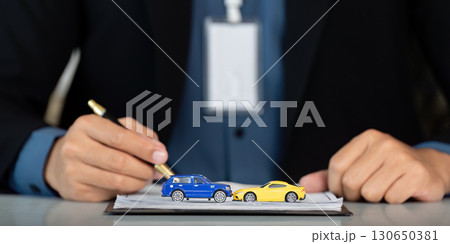 Car Insurance Discussion. Professional writing details about model cars during consultation. 130650381
