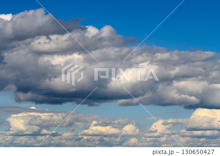 A Dramatic Cloudscape Beneath a Vast Blue Sky With Beautiful Scenery Enhancing the Atmosphere A Dramatic Cloudscape Beneath a Vast Blue Sky With Beautiful Scenery Enhancing the Atmosphere 130650427