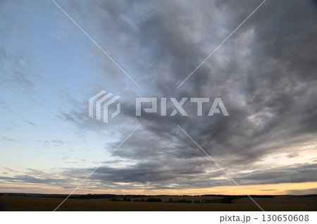 Dramatic and breathtaking Cloudscape at Dusk Over Wide Open Fields, showcasing natures beauty Dramatic and breathtaking Cloudscape at Dusk Over Wide Open Fields, showcasing natures beauty 130650608