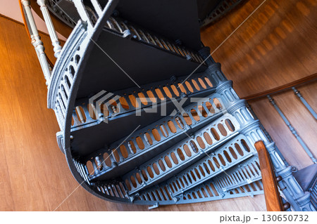 A finely crafted spiral staircase made of metal featuring detailed designs A finely crafted spiral staircase made of metal featuring detailed designs 130650732
