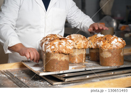 Baker showing a tray with traditional Panettone 130651493