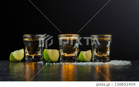 Tequila with lime and salt on a stone table. Tequila with lime and salt on a stone table. 130652454