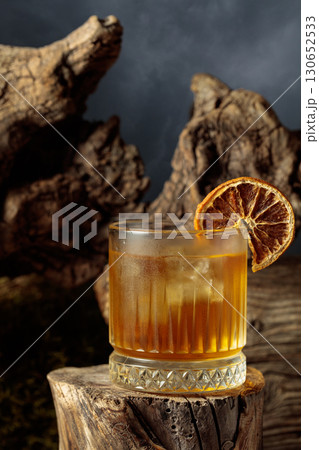 Old-fashioned cocktail with ice and dried orange slice. Old-fashioned cocktail with ice and dried orange slice. 130652533