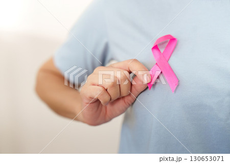 Breast Cancer Awareness. Individual holding pink ribbon close. 130653071
