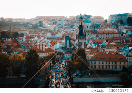 Tourists walking on Charles Bridge in Prague with the famous Prague Castle and st. Vitus cathedral in background 130653175