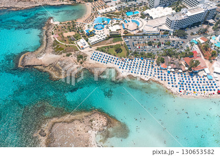 Turquoise water surrounding beachgoers relaxing on the coast of cyprus 130653582