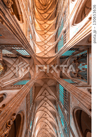 Sunlight shines through stained glass windows illuminating medieval gothic St. Vitus Cathedral vaulted ceiling. Prague, Czech Republic 130653636
