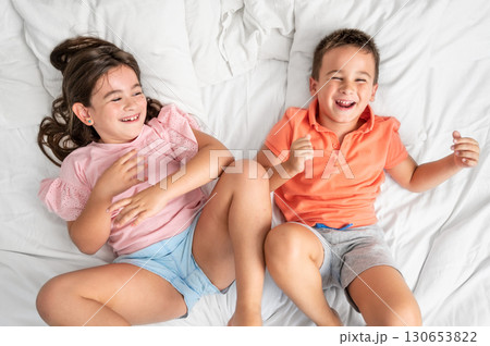 Joyful little children playing on bed. 130653822