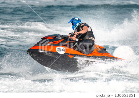 Pilot is riding a jet ski during a competition on the sea Pilot is riding a jet ski during a competition on the sea 130653851