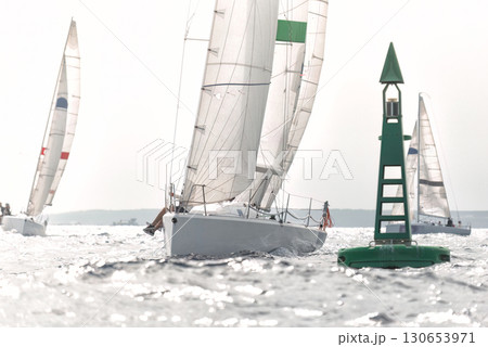 Sailboat passing green buoy during regatta with other boats competing Sailboat passing green buoy during regatta with other boats competing 130653971