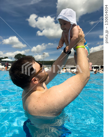 Father Lifting Baby in Pool on Sunny Day Father Lifting Baby in Pool on Sunny Day 130654094
