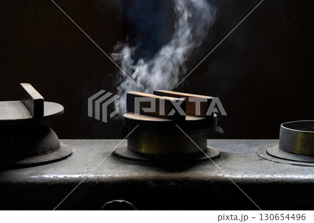 湯気と炎がゆらめく古民家のかまど 130654496