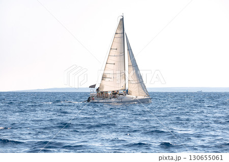 Graceful yacht sails in the glistening mediterranean sea during a competitive regatta 130655061