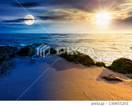beach with sand. day and night time change concept. summer solstice at the seaside. beautiful seascape with calm waves under sun and moon at twilight. landscape at the sea under sky with fluffy clouds beach with sand. day and night time change concept. summer solstice at the seaside. beautiful seascape with calm waves under sun and moon at twilight. landscape at the sea under sky with fluffy clouds 130655201