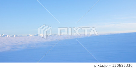 青空と十勝岳連峰を望む北海道美瑛町の冬の雪原風景 130655336