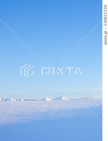 青空と十勝岳連峰を望む北海道美瑛町の冬の雪原風景 青空と十勝岳連峰を望む北海道美瑛町の冬の雪原風景 130655338