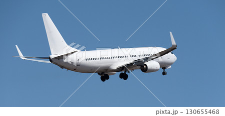 Airplane take off on the blue sky, Aircraft flying on sky background. White passenger jet plane in the blue sky. Low angle view of Airplane flying under blue sky 130655468