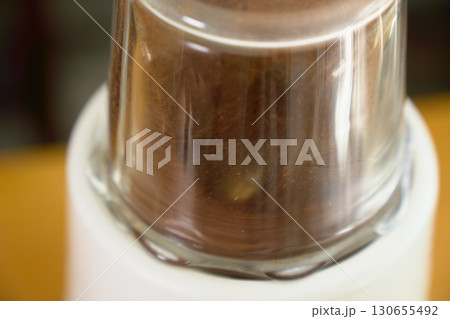 電動ミルでコーヒー豆を挽いている様子。ペーパードリップでコーヒーを淹れる工程の連続写真。 130655492