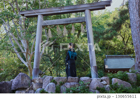 鳥居の前でポーズをする着物姿の女性｜日本庭園・和風・観光イメージ 130655611