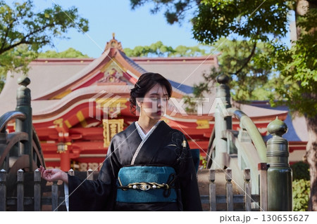 朱塗りの拝殿を背景にポーズをとる振袖姿の女性|神社・着物・伝統美 朱塗りの拝殿を背景にポーズをとる振袖姿の女性|神社・着物・伝統美 130655627
